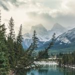 Banff Park - green pine trees near lake and snow covered mountain during daytime