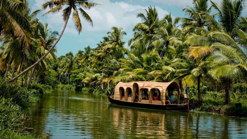 Kerala Backwaters - brown boat on body of water near green trees during daytime