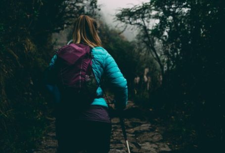 Inca Trail - woman wearing bubble jacket walking on pathway between forest