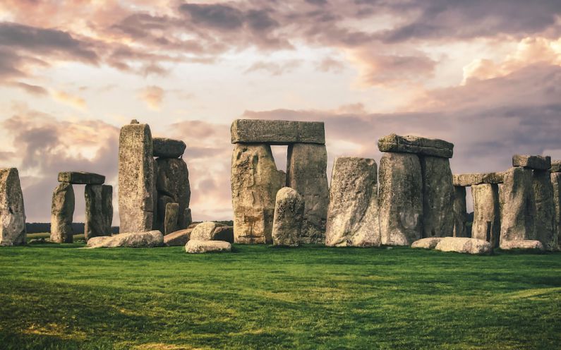 Stonehenge - gray rock formation on green grass field under gray cloudy sky