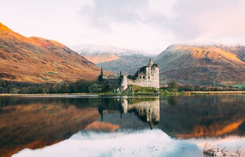Scottish Highlands - gray concrete building near lake under white sky during daytime