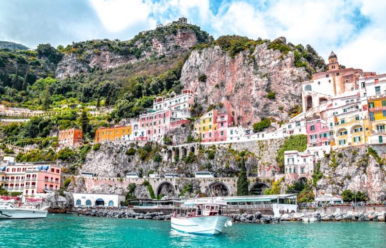 Amalfi Coast - white boat on body of water near green and brown mountain during daytime