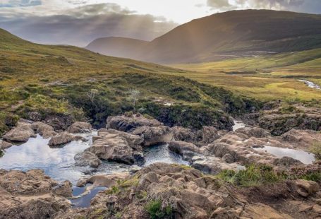 Fairy Pools - river between green grass field under white clouds during daytime