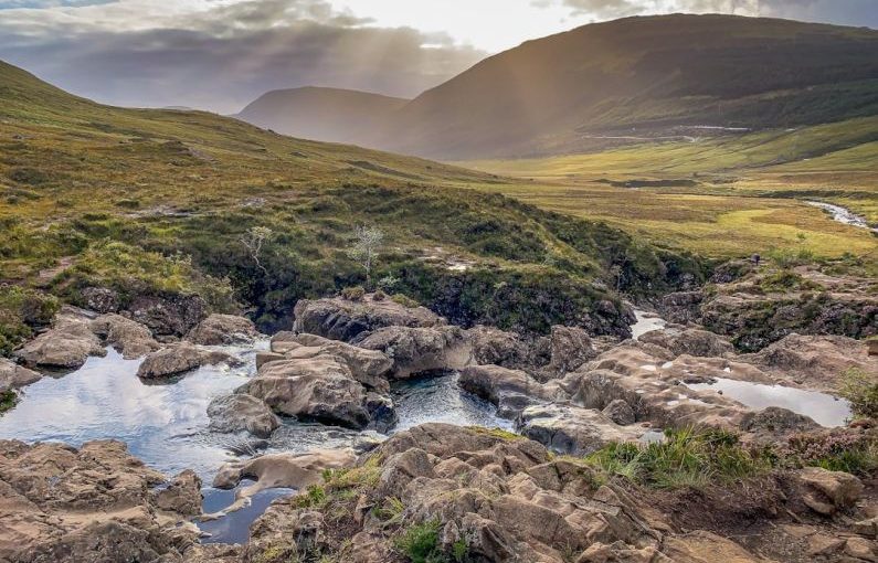 Fairy Pools - river between green grass field under white clouds during daytime
