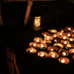 Varanasi Ganges - a bunch of lit candles sitting on top of a table